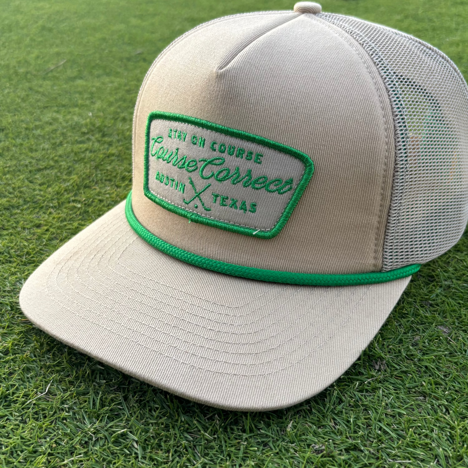 Beige cap with green logo on grass